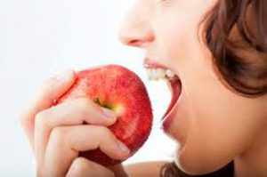 woman biting into apple